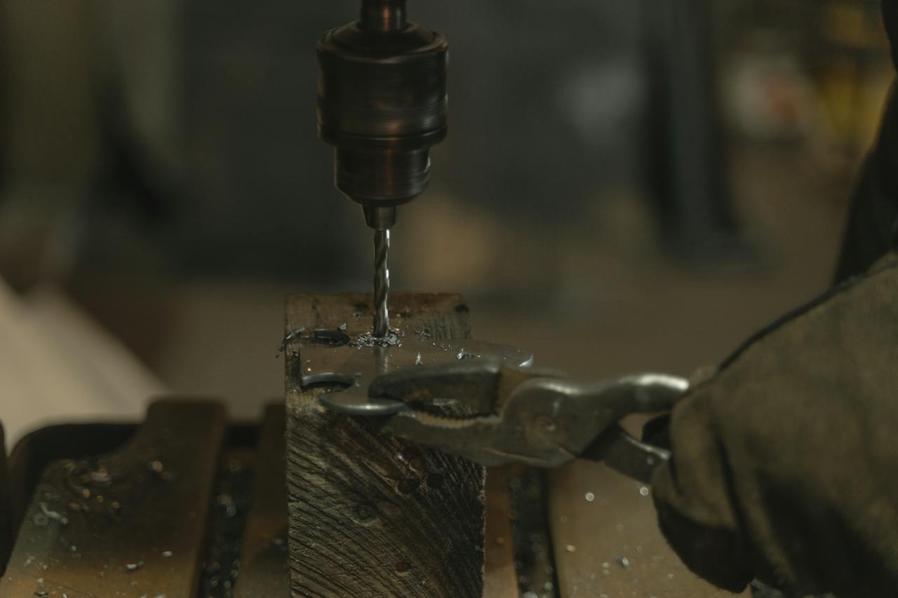 Close-Up Shot of a Person Drilling a Metal